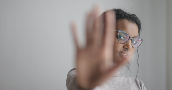 Main floue en avant-plan d'une étudiante issue de la diversité